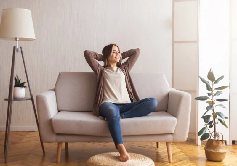 millennial girl relaxing at home on couch, enjoying weekends, empty space