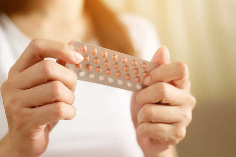 woman hands opening birth control pills in hand eating contraceptive pill contraception reduces childbirth and pregnancy concept