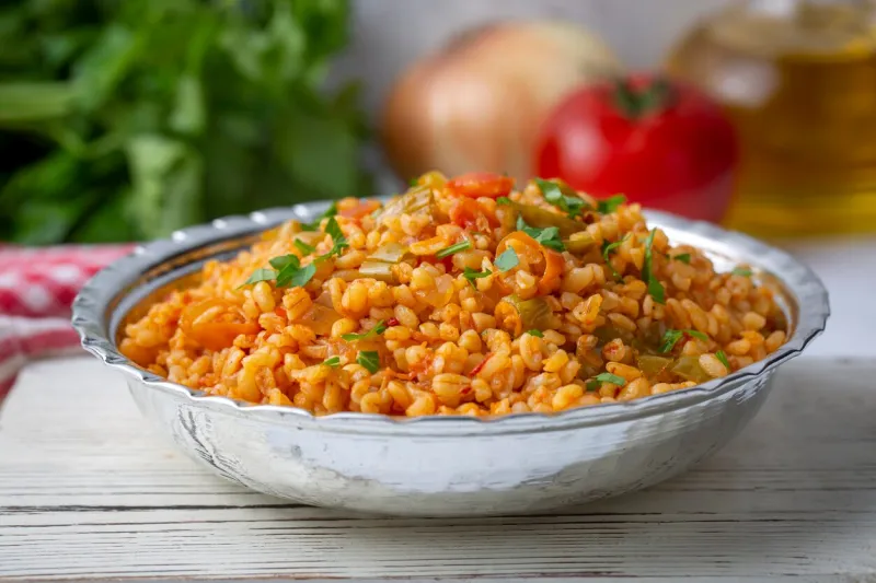 traditional turkish bulgur pilaf with tomato sause in plate (turkish name, meyhane pilavi)