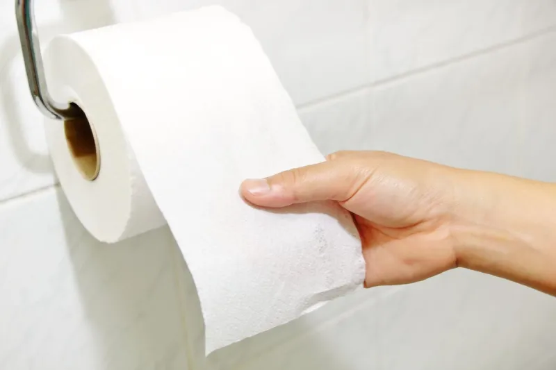 woman hand holding the roll of toilet paper