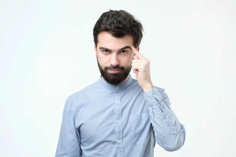 let me think serious hispanic man with beard, keeps index finger on temple, recollect something in mind, remembers information