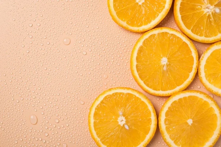 sunny summer concept top above overhead close up view photo of juicy orange slices on table with water drops with place for text copy blank empty space