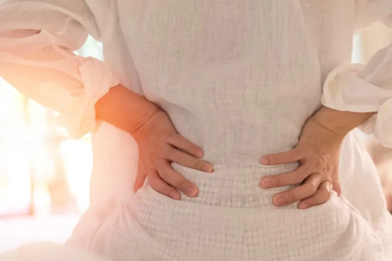 back pain in woman concept female patient hurt from lower backache from bowel and bladder problems, palvic inflammatory disease (pid) or motherhood pregnancy