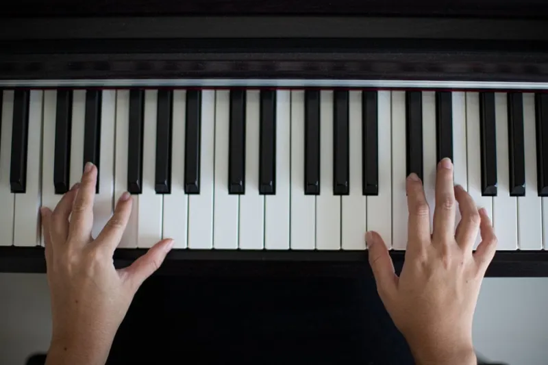 manos sobre un piano aprendiendo a tocar