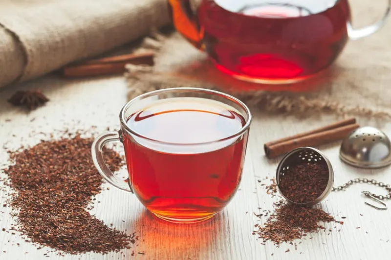 thé rooibos bio traditionnel sain avec des épices dans un style rustique avec filtre instagram fané sur une table en bois vintage