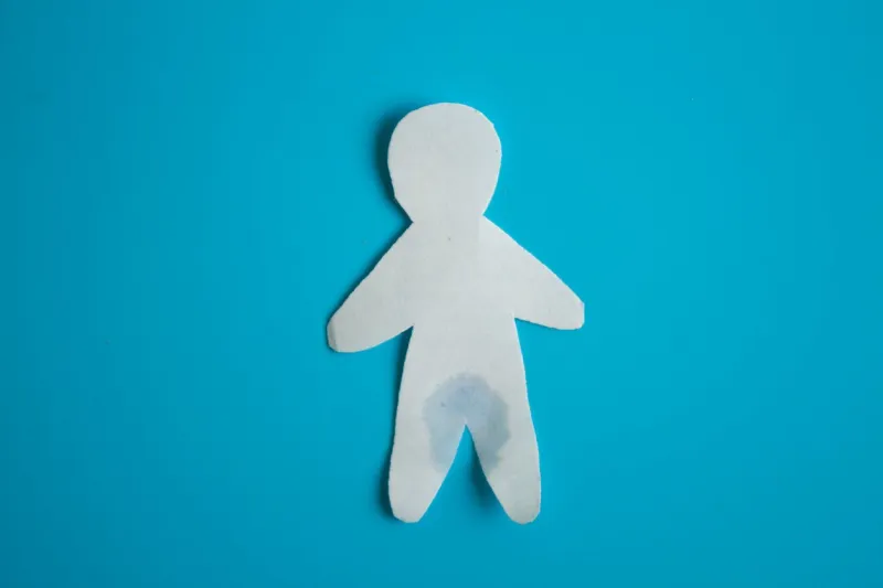 urinary incontinence concept wet paper person blue background