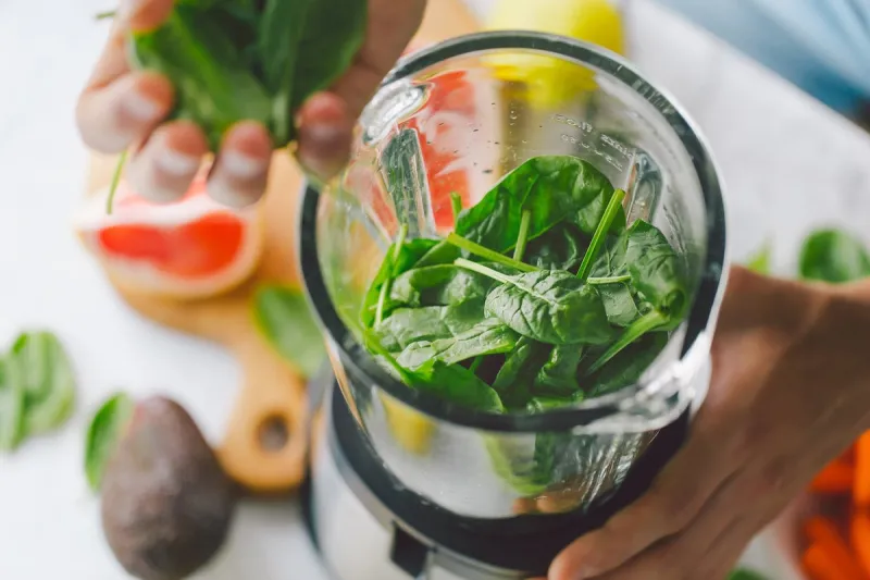 man cooking healthy detox smoothie with fresh fruits and green spinach lifestyle detox concept