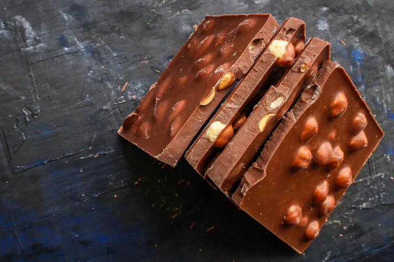 chocolate bar hazelnuts and almonds (delicious sweet dessert snack) menu concept background top view copy space