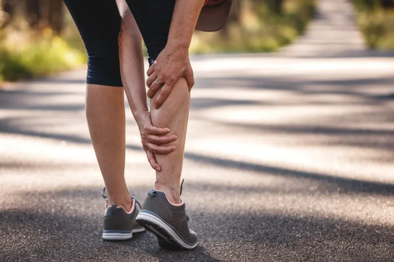 woman feeling pain of her legs during jogging calf muscle cramp underestimating the warm-up exercise before running