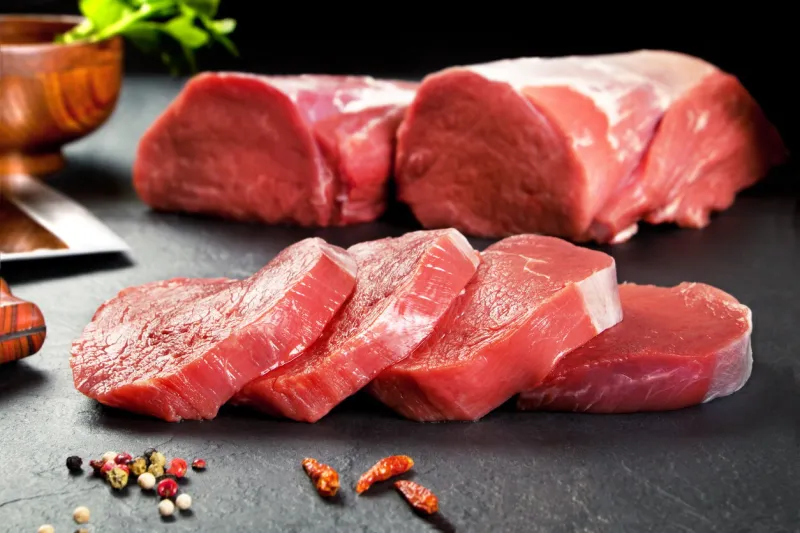 fresh and raw meat sirloin medallions steaks in a row ready to cook background black blackboard