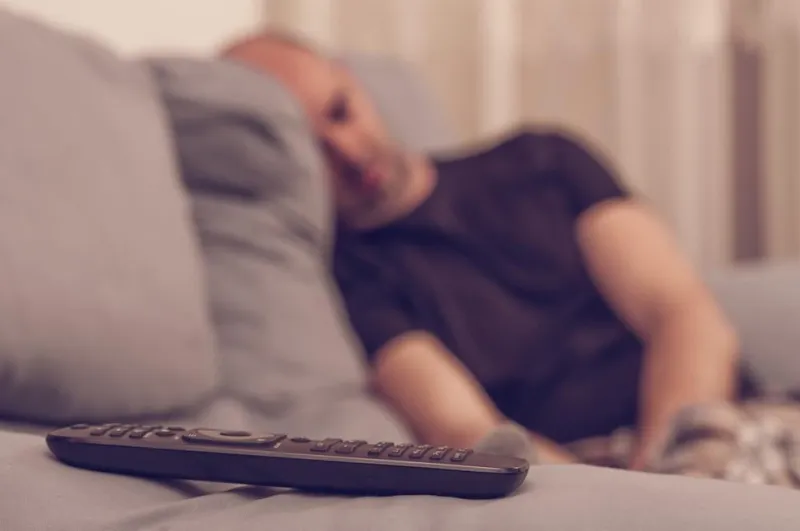 jeune homme, dormir dans le canapé, regarder la télévision