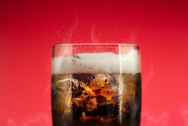 soft drink glass with ice splash on cool smoke background cola glass with summer refreshment