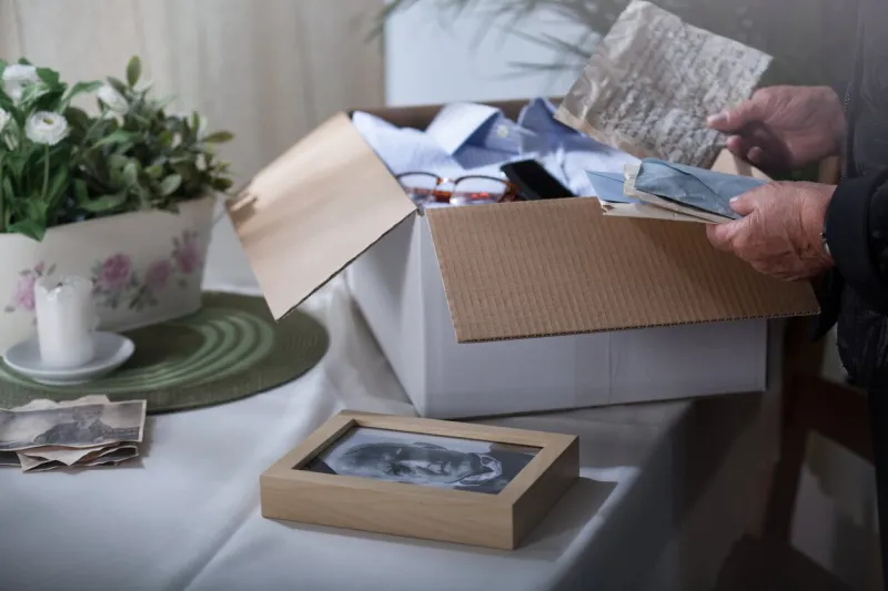 woman in mourning packing remembrances after dead husband