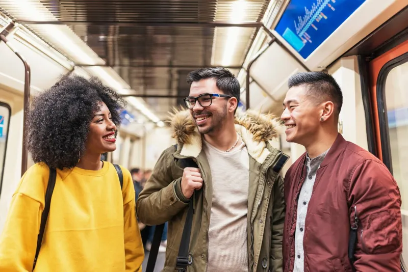 group of happy friends chatting in the subway friendship concept