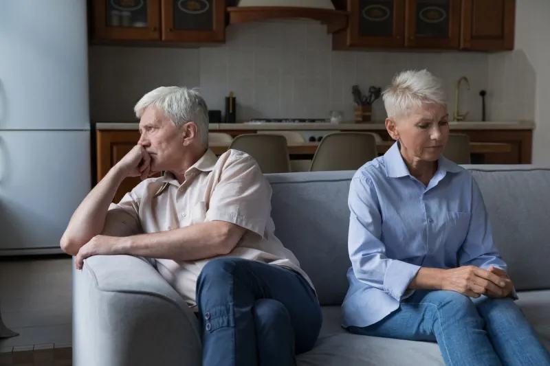 serious thoughtful unhappy older 60s wife and husband sit on couch separately couple experiencing marriage crisis, lack of understanding and patience, break up and hard decision about divorce concept