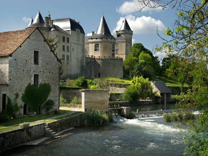 the river charente at verteuil, france showing the chateau and other town buildings