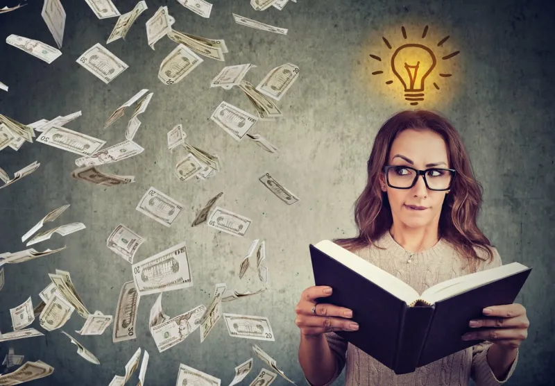 woman student reading a book has a bright idea how to earn money