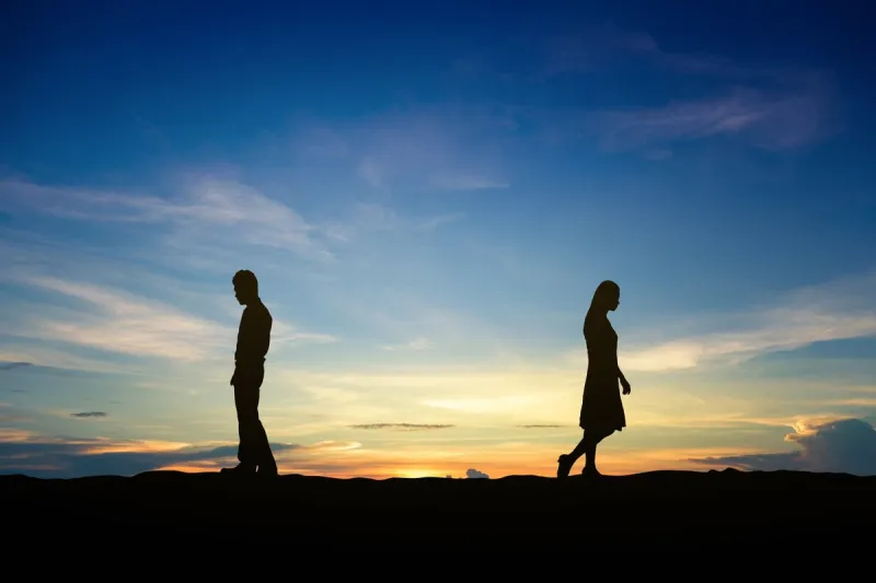 silhouettes of couple man and woman broken heart at nature sunse