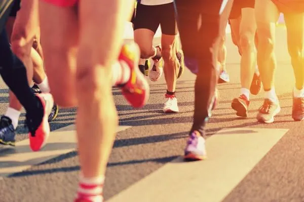 jambes de coureur de marathon en cours d'exécution sur la rue de la ville