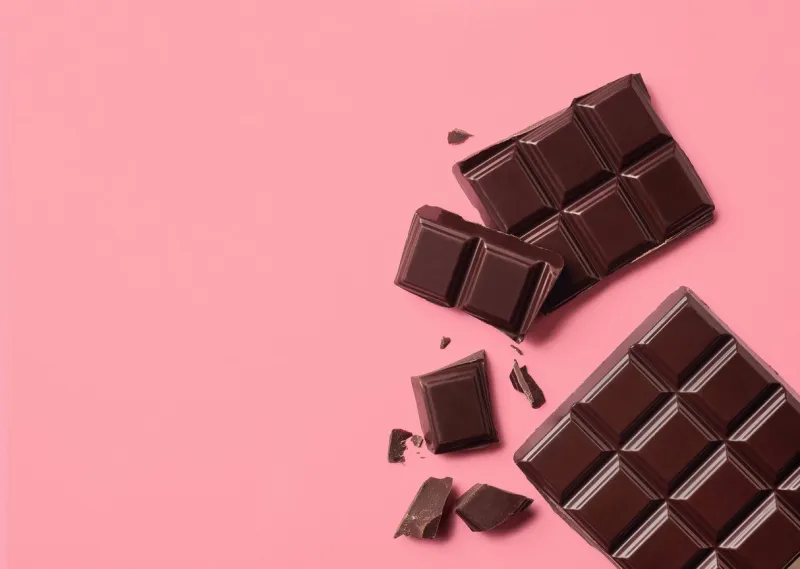 dark chocolate on pink background top view