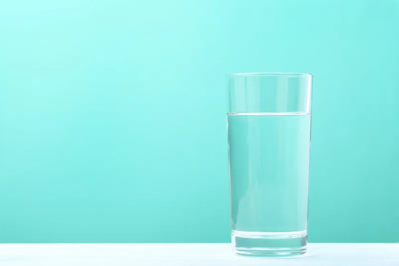 glass with water on mint background