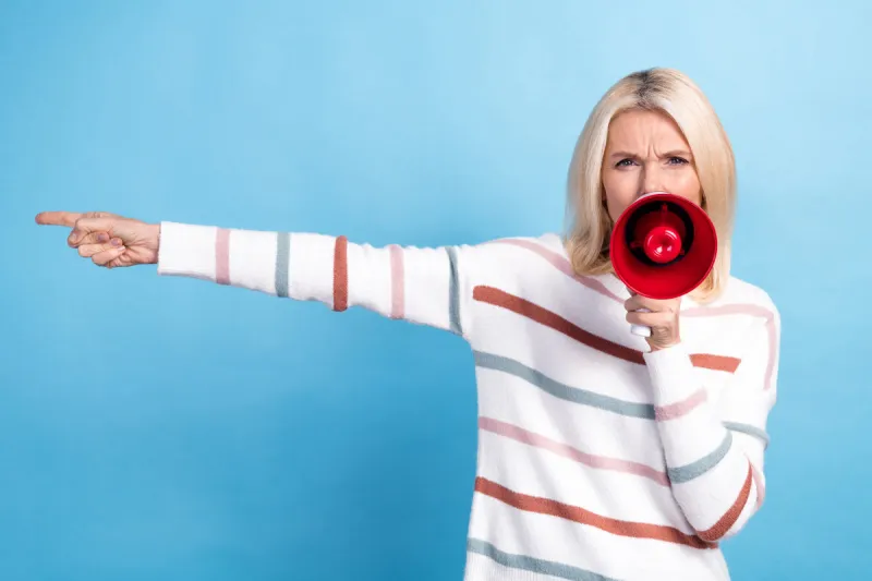 photo of mad furiious retired lady stand for wоman rights hand showing empty space advert banner isolated on blue color background