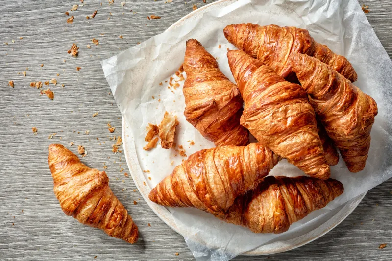 freshly baked croissants on grey wooden table, top view