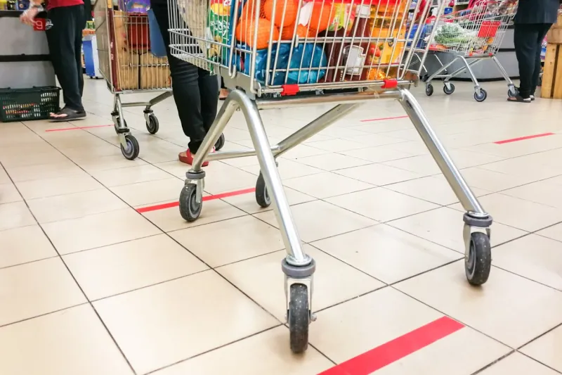social distancing being practiced at supermarket payment counter in malaysia, with 1 meter gap between people in queue