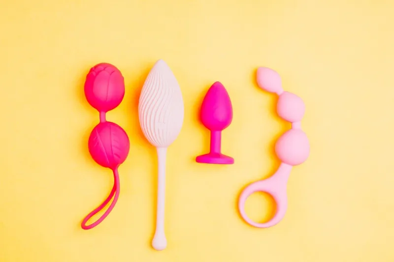 different sex toys set on a yellow background empty space for your text sex shop advertising top view springtime