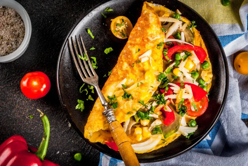 healthy breakfast food, stuffed egg omelette with vegetable, dark concrete background copy space top view