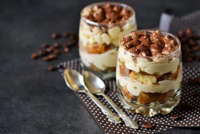 classic tiramisu in a glass jar on the background chermon