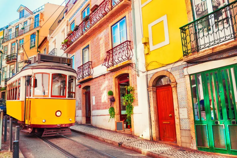 yellow vintage tram on the street in lisbon, portugal famous travel destination