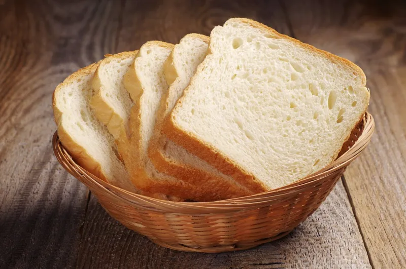 toast bread in wicker basket on old wooden table