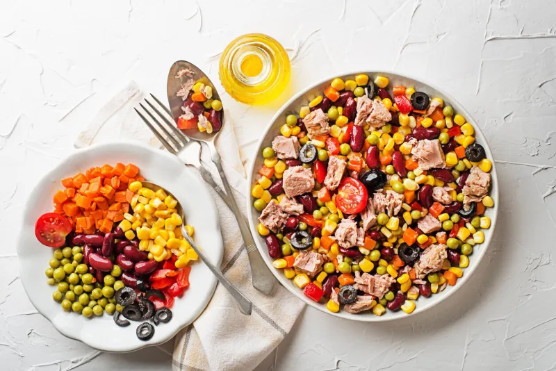healthy tuna salad with canned mixed vegetable on white table background mexican corn salad