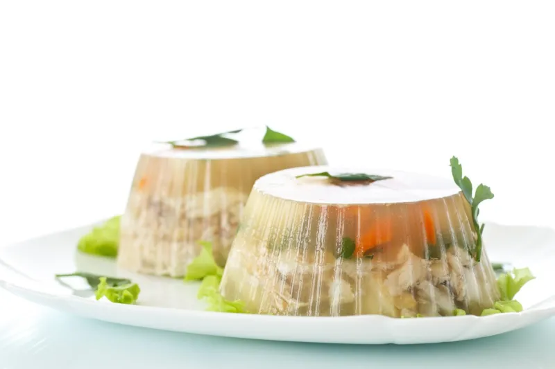 jellied fish with egg and vegetables on a white background