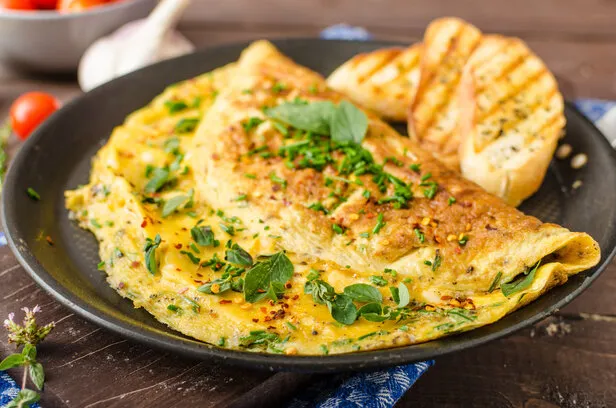 herb omelette with chives and oregano sprinkled with chili flakes, garlic panini toasts