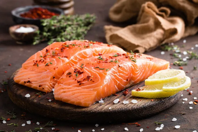 fresh salmon fish fillet on wooden board