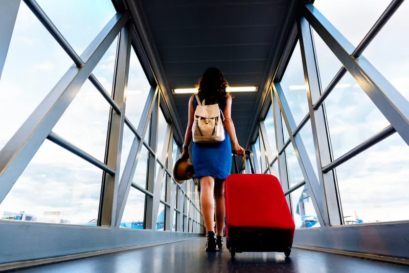 young girl traveler walking with carrying hold suitcase in the airport tourist concept