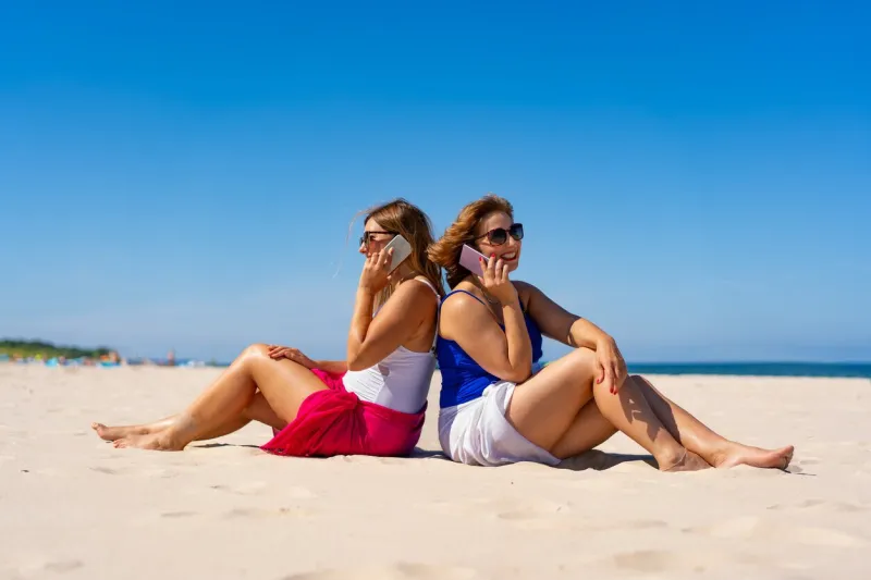 happy and relaxed women in their 40s on vacation at seashore