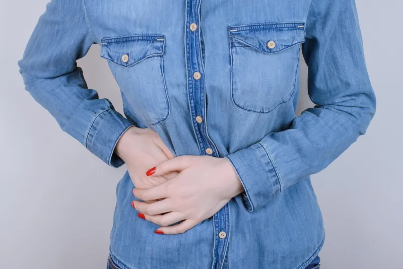 stomach-ache concept cropped close up photo of sad upset depressed person people lady gripping right side with hands feeling acute pain isolated on gray background