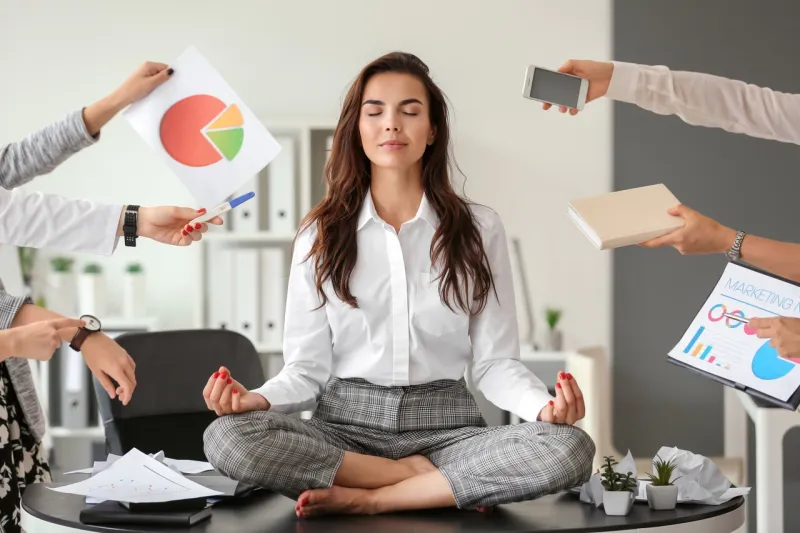 businesswoman with a lot of work to do meditating in office