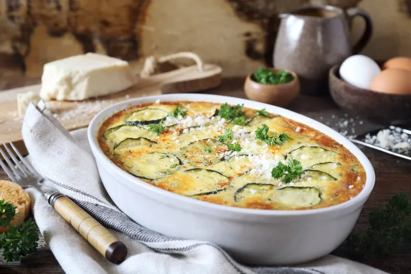 french cuisine vegetable zucchini clafoutis (gratin) with parmesan cheese in ceramic bakeware, rustic style