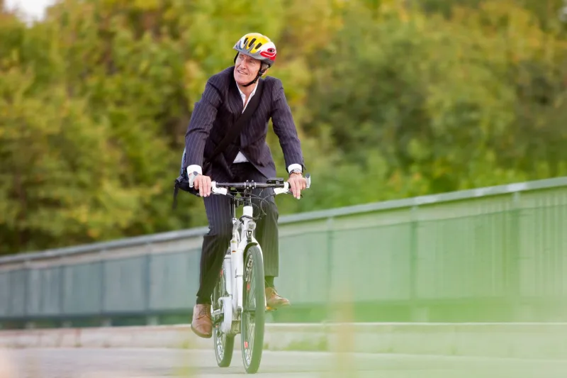 businessman riding bicycle on bridge