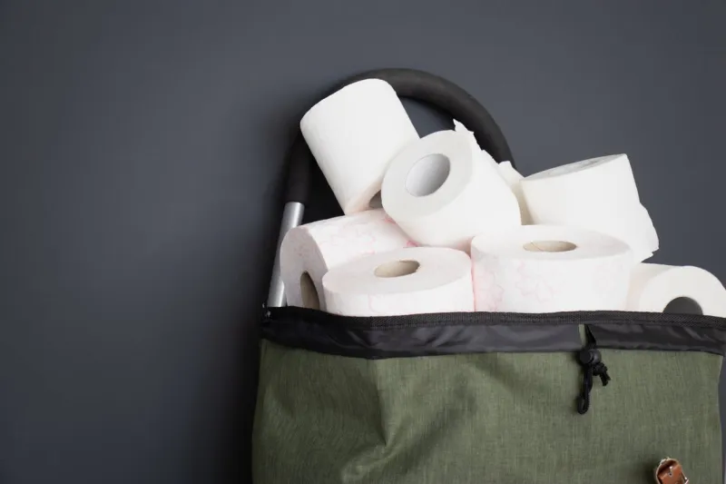 close-up of shopping trolley on black background trolley, sale concept isolated over black background in a cart lies a toilet paper