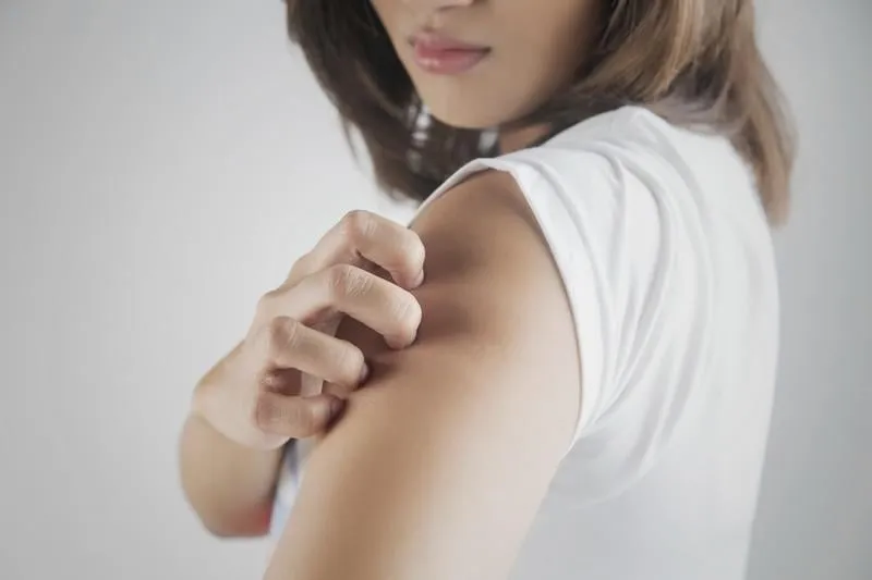 femme se gratter le bras