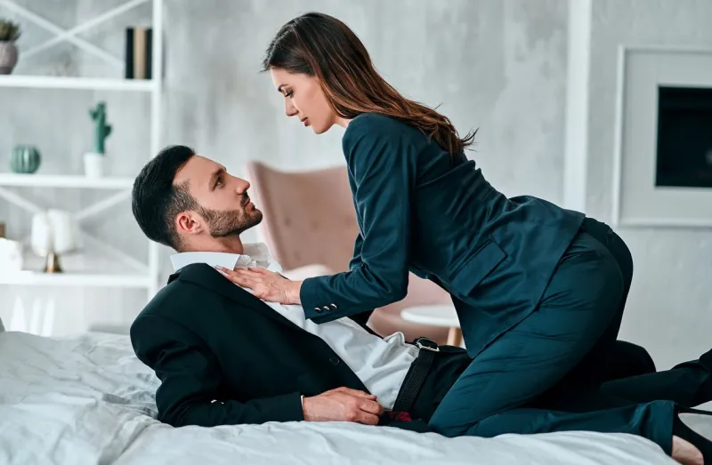 the man and woman in suits playing in the bed