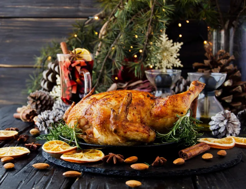 roast chicken or turkey for christmas and new year with mulled wine and christmas decorations, selective focus