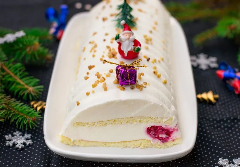sweet christmas cake yule log with cream cheese, mascarpone and raspberries, cheesecake style