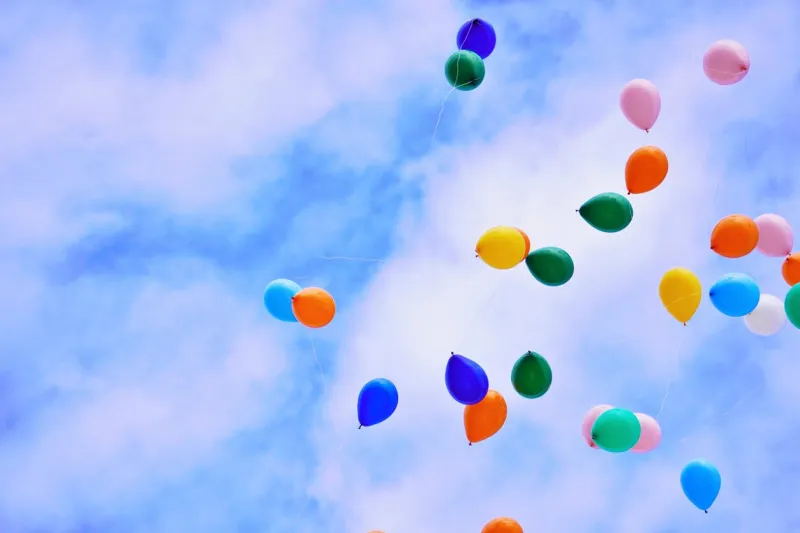 various colored wind balloons flying in the blue sky