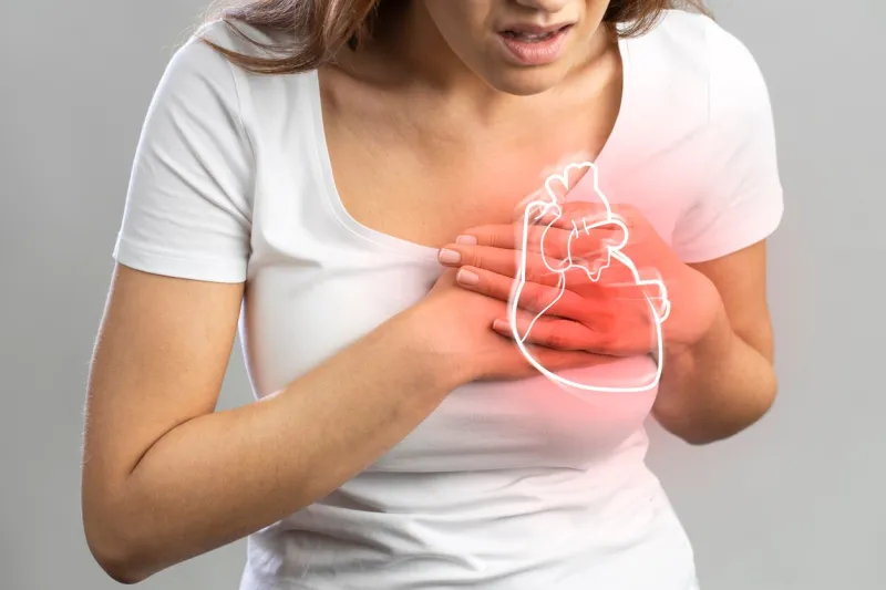 young woman pressing on chest with painful expression severe heartache, having heart attack or painful cramps, heart disease